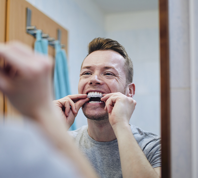 Man preparing silicon tray for teeth whitening
