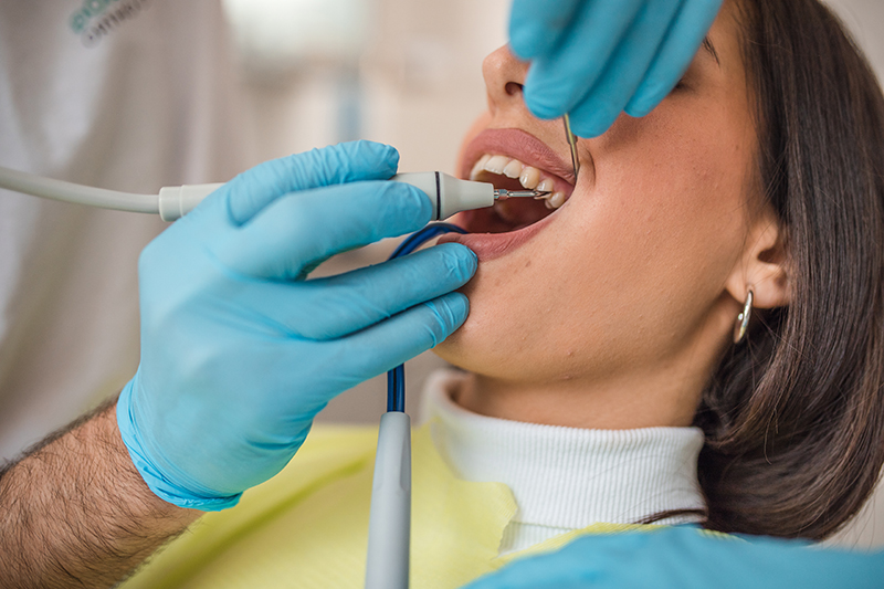 Dentist removing dental calculus from the patient in the dental office