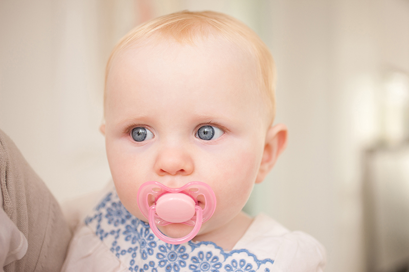 Close up of baby with pink pacifier